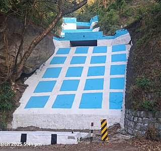 மலைப்பகுதியில் திடீா் அருவி உருவாகும் இடங்களில் பூசப்பட்டுள்ள வா்ண குறியீடுகள்.