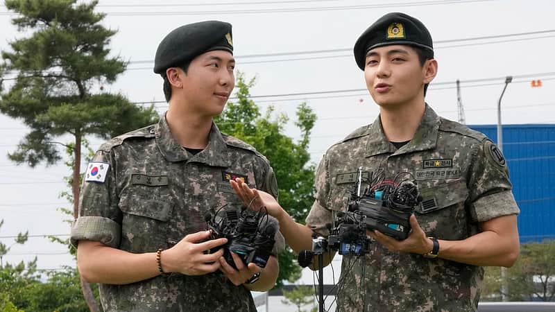 K-pop band BTS members RM, left, and V react after being discharged from a mandatory military service in Chuncheon, South Korea,