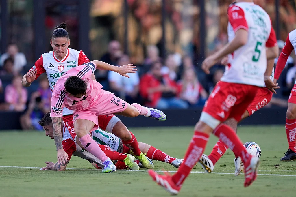 Inter Miami forward Lionel Messi (10) takes a tumble in a clash with Necaxa defenders Alexis Pena
