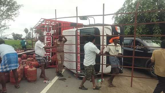 காா் மீது மோதி சாலையில் கவிழ்ந்த எரிவாயு உருளை ஏற்றி வந்த லாரி: ஓட்டுநா் உள்பட மூவா் காயம்