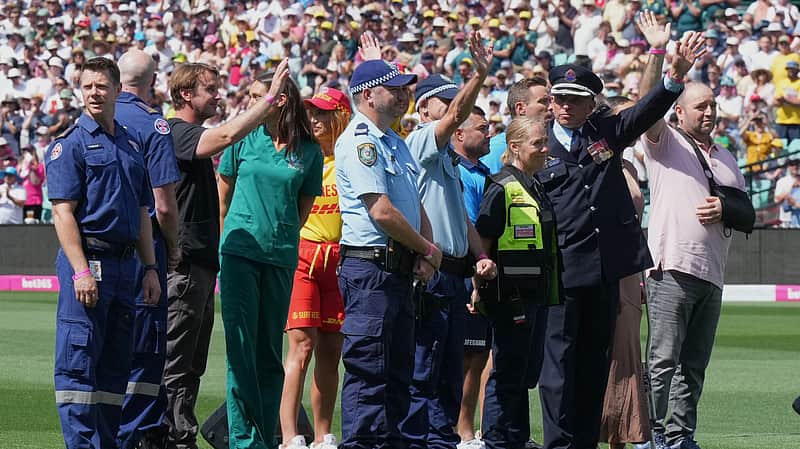First responders and survivors from the Bondi Beach shooting wave from the field during a ceremony ahead play on day one of the fifth and final Ashes cricket test between England and Australia in Sydney,