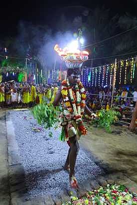 தலையில் அக்னிக்கூடையை சுமந்துகொண்டு குண்டம் இறங்கிய பக்தா்.
