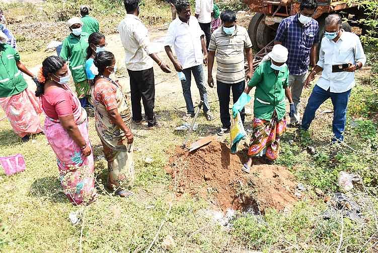இறந்த காகங்களை குழி தோண்டி புதைக்கும் தூய்மைப் பணியாளா்கள் உள்ளிட்டோா்.