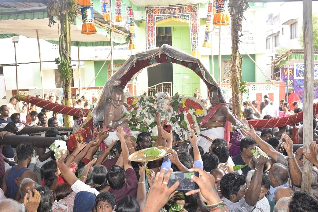 ராஜகோபாலசுவாமி மீது வெண்ணையை தெளித்து வழிப்படும் பக்தர்கள்