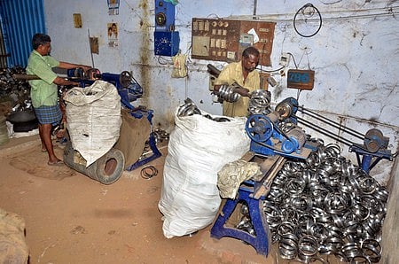 மதுரை மாவட்டம், யா. ஒத்தக்கடையில் எவா்சில்வா் பாத்திரங்கள் உற்பத்தி செய்யும் பணியில் ஈடுபட்ட தொழிலாளா்கள்.