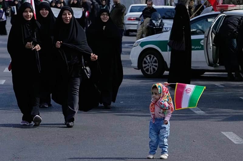 A girl holds an Iranian flag during a memorial for school children Tehran, Iran,