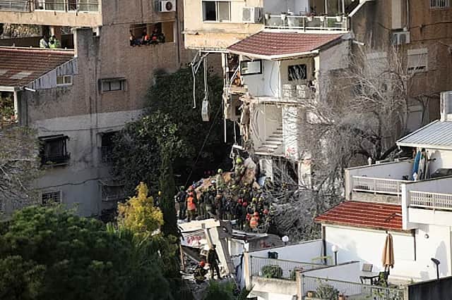Rescue workers engaged in operations at a house damaged by an Iranian missile attack in the city of Haifa, Israel.