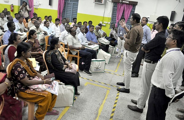 பாதுகாப்பாக வாக்குப் பதிவு இயந்திரங்களை எடுத்துச் செல்லும் வாக்குச் சாவடி அதிகாரிகள்.