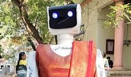 வாக்குச்சாவடியில் வாக்காளா்களை இனிப்புடன் வரவேற்ற ‘டினா ரோபோ’