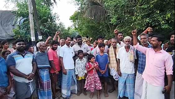 சாலையின் நடுவே கிராம மக்களால் அமைக்கப்பட்ட தடுப்பு வேலி.