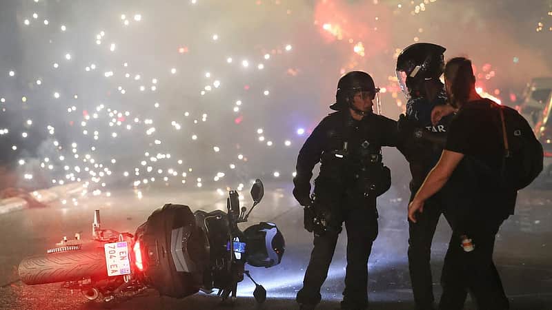 Police try to disperses PSG supporters who left off fireworks as they celebrate in Paris, Saturday, May 30, 2026 after the Champions League final soccer match between Paris Saint-Germain and Arsenal that was played in Budapest, PSG won the game. (AP Photo/Thomas Padilla)