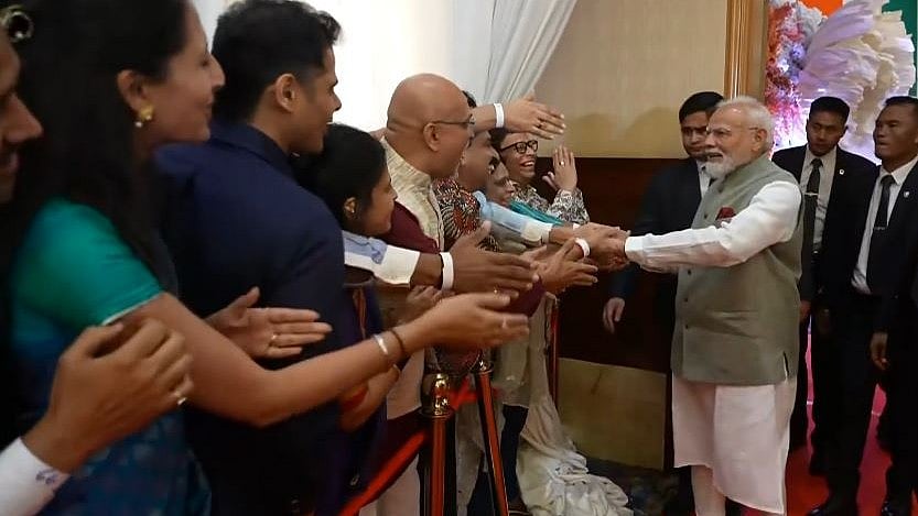 இந்திய வம்சாவளியினர்களுடன் கைக்குலுக்கி மகிழும் பிரதமர் மோடி.