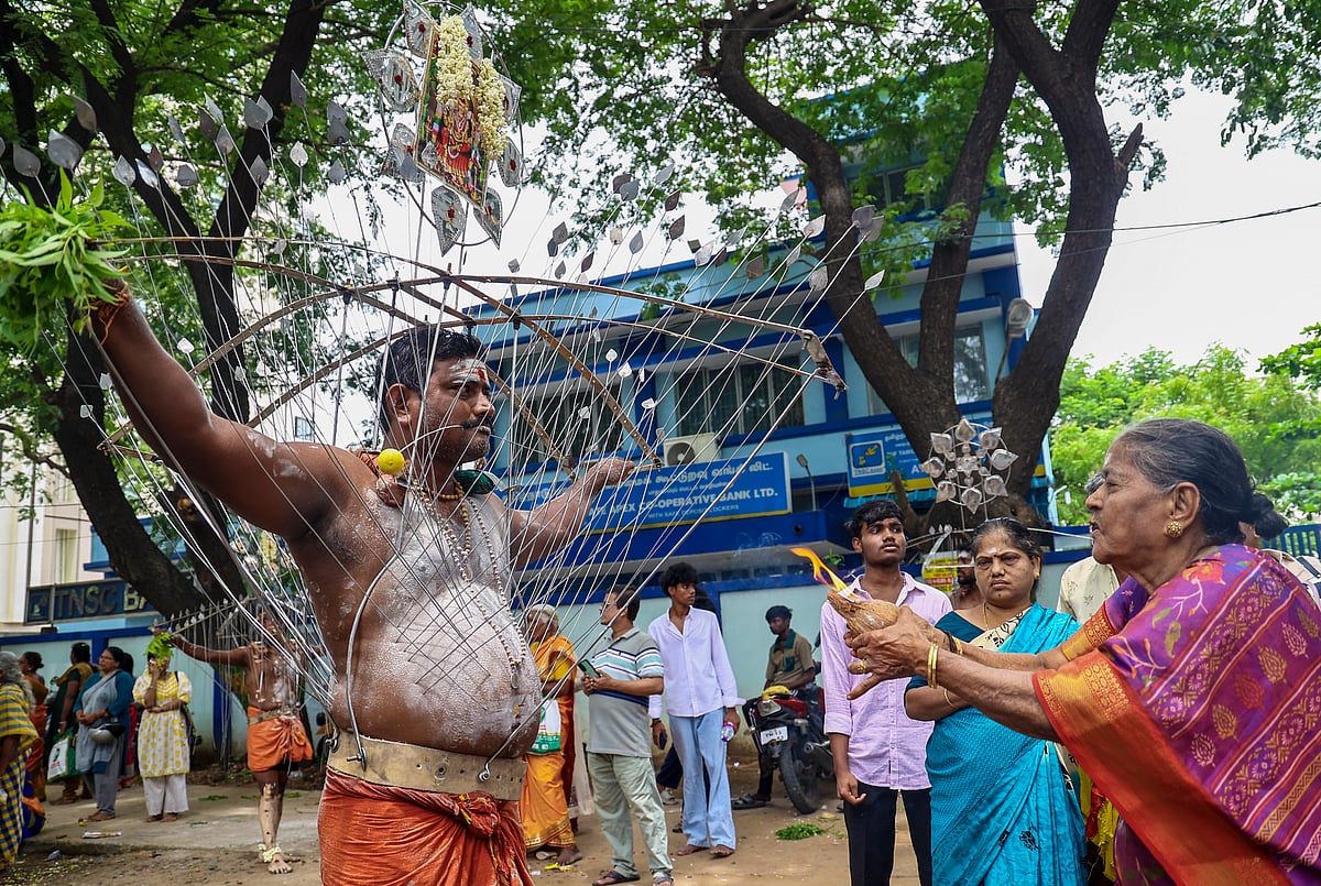 திருவிழாவில் வேண்டுதலை நிறைவேற்றும் வகையில் அலகு குத்தியும், தீச்சட்டி ஏந்தி வரும் பக்தர்.