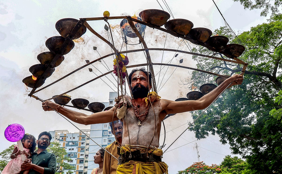 அலகு குத்தியும், தீச்சட்டி ஏந்தி வரும் பக்தர்.