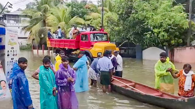 பொதுமக்களைப் படகுகள் மூலம் பாதுகாப்பான இடங்களுக்கு அழைத்துச் செல்லும் மீட்புக் குழுவினர்.