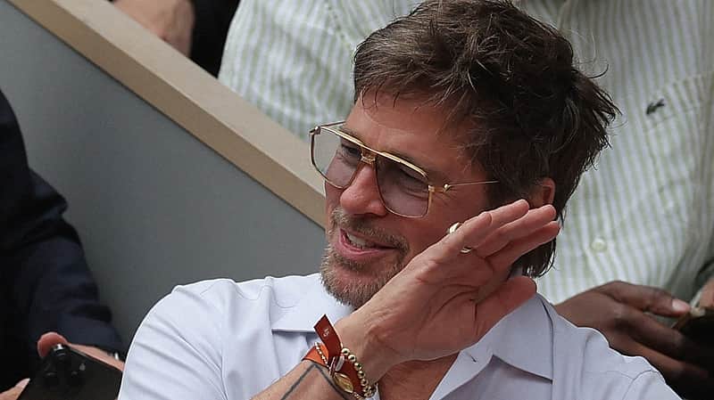 US actor Brad Pitt gestures on Court Philippe-Chatrier ahead of the women's final singles match on day 14 of the French Open tennis tournament at the Roland-Garros Complex in Paris on June 6, 2026. (Photo by Thomas SAMSON / AFP)