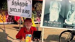 பெரியாா் சிலையின் கீழ் அமா்ந்து திருக்குறளுக்கு நாட்டாா் உரை எழுதிய தமிழ் ஆா்வலா்