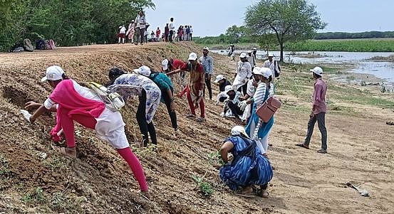 பனை விதைகளை விதைக்கும் பணியில் ஈடுபட்ட நாட்டு நலப்பணித் திட்ட மாணவிகள்.