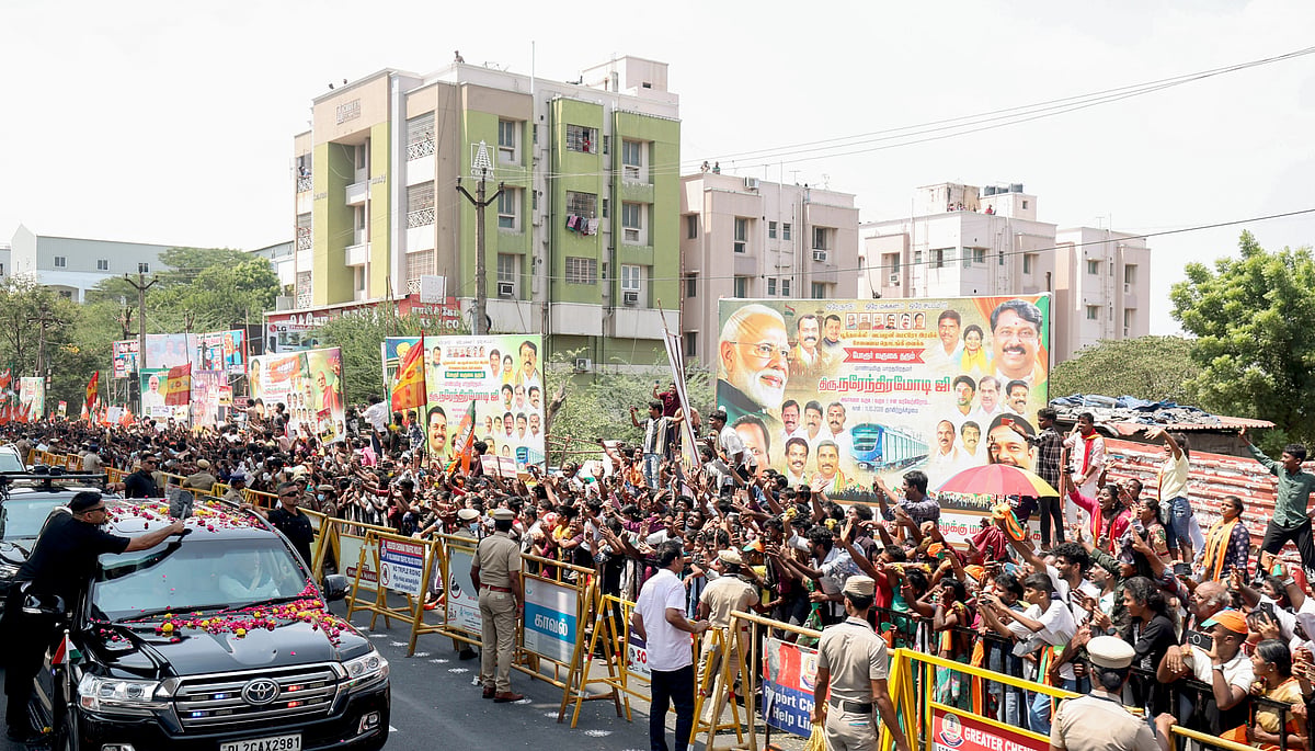 தனது வாகனத்தில் இருந்தவாறே மக்களை நோக்கி கையசைக்கும் பிரதமர் நரேந்திர மோடி.