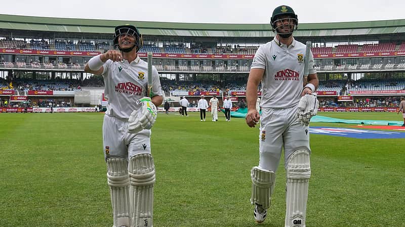 South Africa's Marques Ackerman, left, and Aiden Markram walk back to the dressing room as rain delays play on day one of the second cricket test match between South Africa and Australia, in Gqeberha, South Africa, Sunday, Oct. 18, 2026. (AP Photo/ Themba Hadebe)