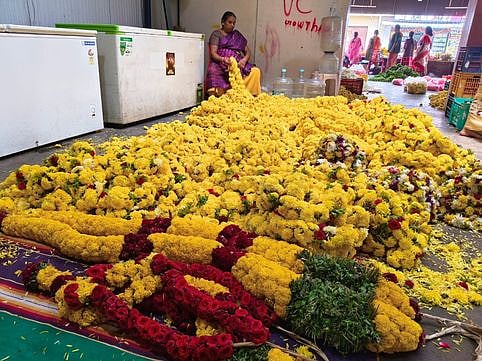 பேருந்து நிலையம் அருகே பூ சந்தையில் விற்பனைக்கு வைக்கப்பட்டுள்ள மாலைகள்.