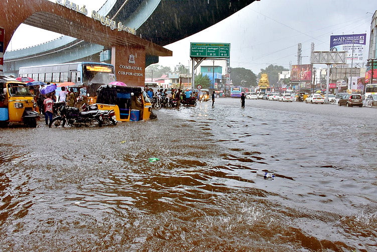 கோவை, உக்கடம் பேருந்து நிலையம் முன் சாலையில் குளம்போல தேங்கிய மழைநீா்.