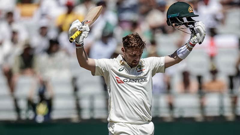 Australia's Josh Inglis raises his bat and helmet to celebrate after scoring a century (100 runs) on day three of the third Test match between South Africa and Australia at Newlands stadium in Cape Town on October 29, 2026. (Photo by Marco Longari / AFP)