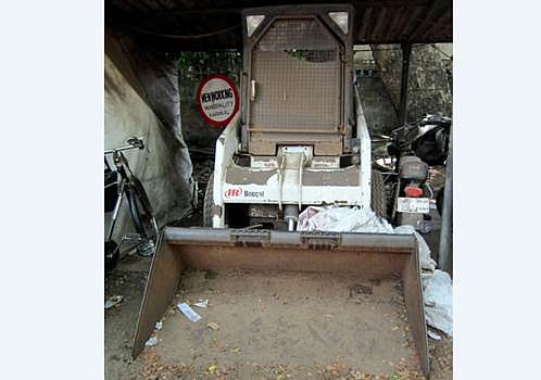 குப்பையோடு சேர்ந்து கிடக்கும் ரூ.18 லட்சத்தில் வாங்கப்பட்ட குப்பை அள்ளும் இயந்திரம்