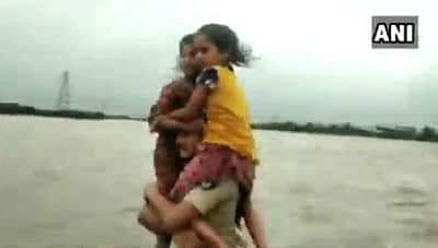 குஜராத் வெள்ளத்தில் சிக்கிய சிறுமிகள் மீட்பு: தோளில் சுமந்து சென்ற காவலருக்கு குவியும் பாராட்டு!