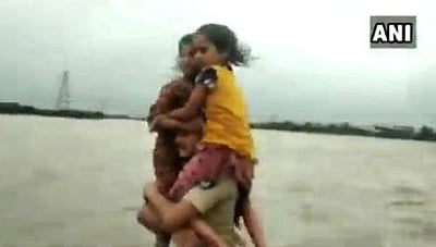 குஜராத் வெள்ளத்தில் சிக்கிய சிறுமிகள் மீட்பு: தோளில் சுமந்து சென்ற காவலருக்கு குவியும் பாராட்டு!