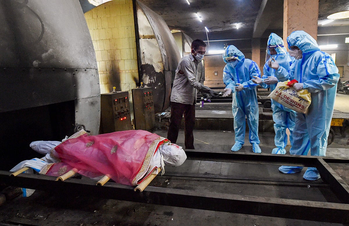 புது தில்லியில் கரோனாவுக்கு பலியானவரின் உடலை உரிய மரியாதையுடன் நல்லடக்கம் செய்யும் சுகாதாரப் பணியாளர்கள். இந்த படம் எடுக்கப்பட்டது கடந்த ஜூன் 24-ம் தேதி.