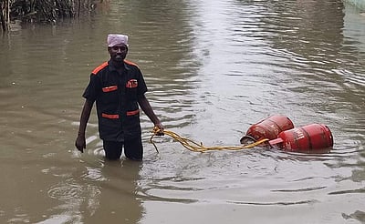 மழை நீர் சூழ்ந்த வீடுகளுக்கு நூதன முறையில் கேஸ் சிலிண்டர் எடுத்துச் சென்ற ஊழியர்
