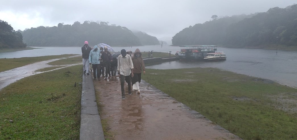 தேக்கடி ஏரியில் கொட்டும் மழையில் சுற்றுலாப் பயணிகள் படகு சவாரி