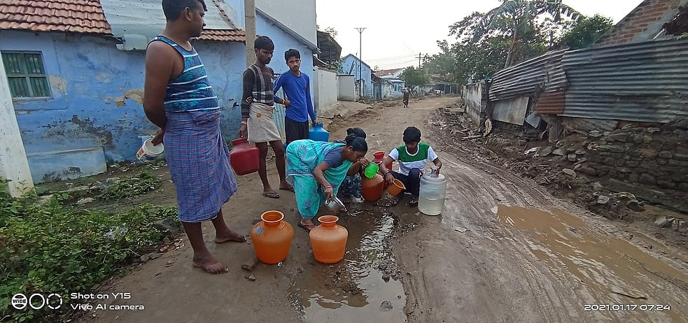 திருப்பூா் அருகே உடைந்த குழாயில் இருந்து வீணாகும் குடிநீரை பிடித்துச் சென்ற பொதுமக்கள்