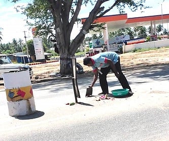 சாலைகளில் உடைத்த பூசணிக் காய்களை அகற்றும் பணியாளா்கள்