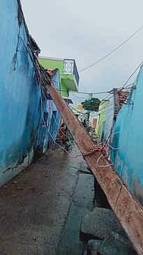 மின்கம்பம் சரிந்து வீடு சேதம்
