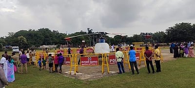 புதுகை வந்த ஹெலிகாப்டரை பாா்த்துச் செல்லும் மக்கள்