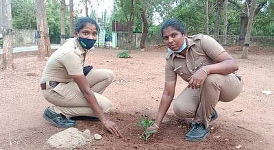 மழை வளத்தை மேம்படுத்துவதற்காக மரக்கன்றுகளை நடும் பெண் காவலா்கள்