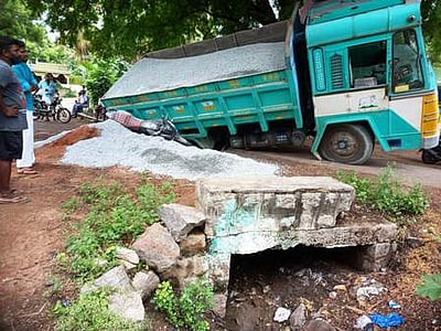தரைப்பாலம் உடைந்ததில் சாய்ந்த லாரி:  அடியில் சிக்கி தாய், மகன் காயம்