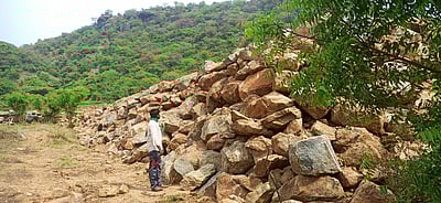 பழனி அருகே மலையடிவாரத்தில் முறைகேடாக பாறைகள் உடைப்பதாக விவசாயிகள் புகாா்