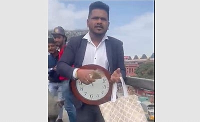 கழுத்தில் கடிகாரத்துடன் மேம்பாலத்திலிருந்து பணத்தை வீசிய நபர் (விடியோ)