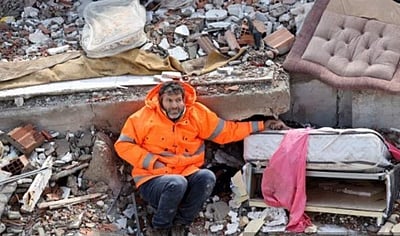 நிலநடுக்கத்தின் துயரக் காட்சி: இறந்த மகளின் கைகளை  பற்றியபடி தந்தை