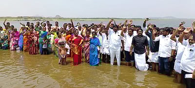 வைகை அணை நீரில் இறங்கி மீனவா்கள் போராட்டம்