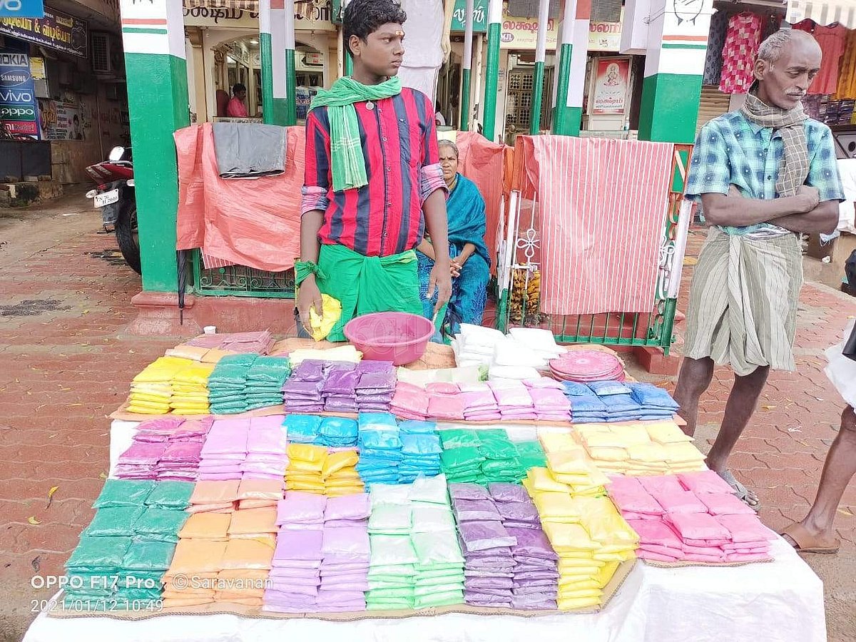 ஆலங்குளம் காமராஜர் சிலை அருகில் கோலப் பொடி விற்பனைக்கு காத்திருக்கும் சிறுவன்