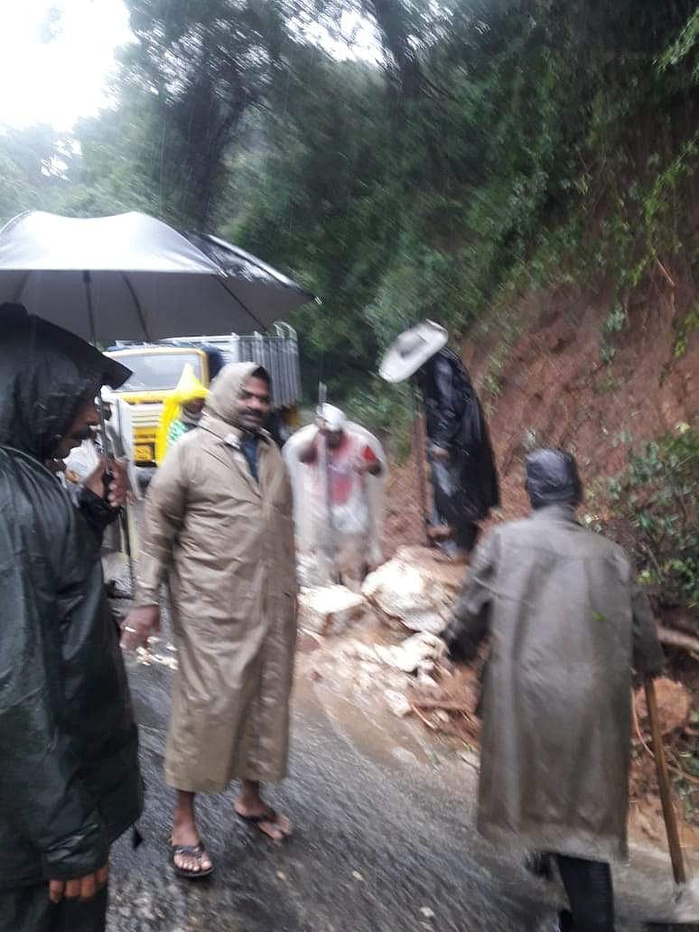 மலைச்சாலையில் ஏற்பட்டுள்ள மண்சரிவை அப்புறப்படுத்தும் தோட்டத் தொழிலாளர்கள்.