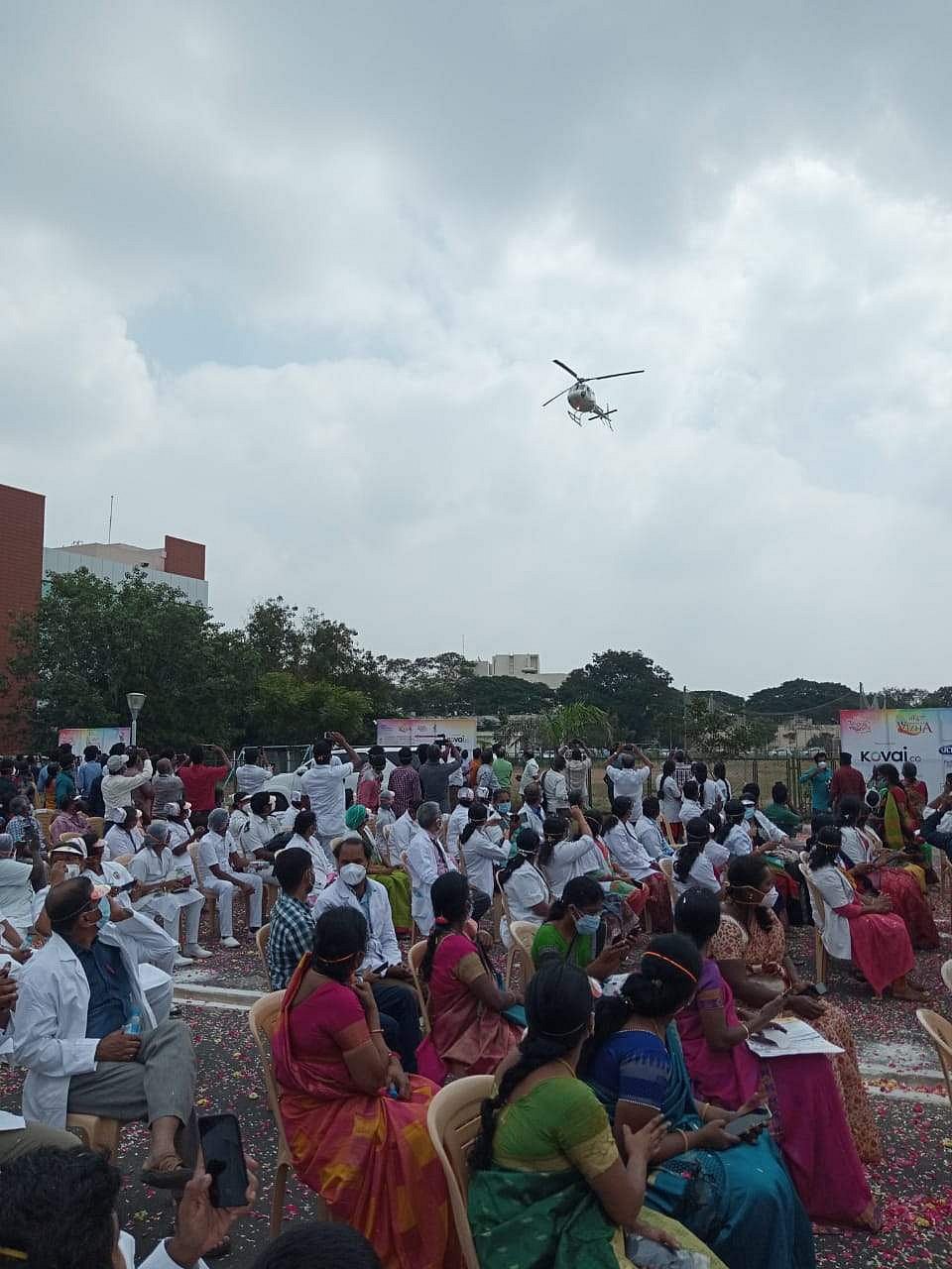 கோவை விழாவின் தொடக்கமாக ஹெலிகாப்டர் மூலம் இ.எஸ்.ஐ. மருத்துவமனை சுகாதாரப் பணியாளர்கள் மீது மலர்கள் தூவப்படுகிறது.