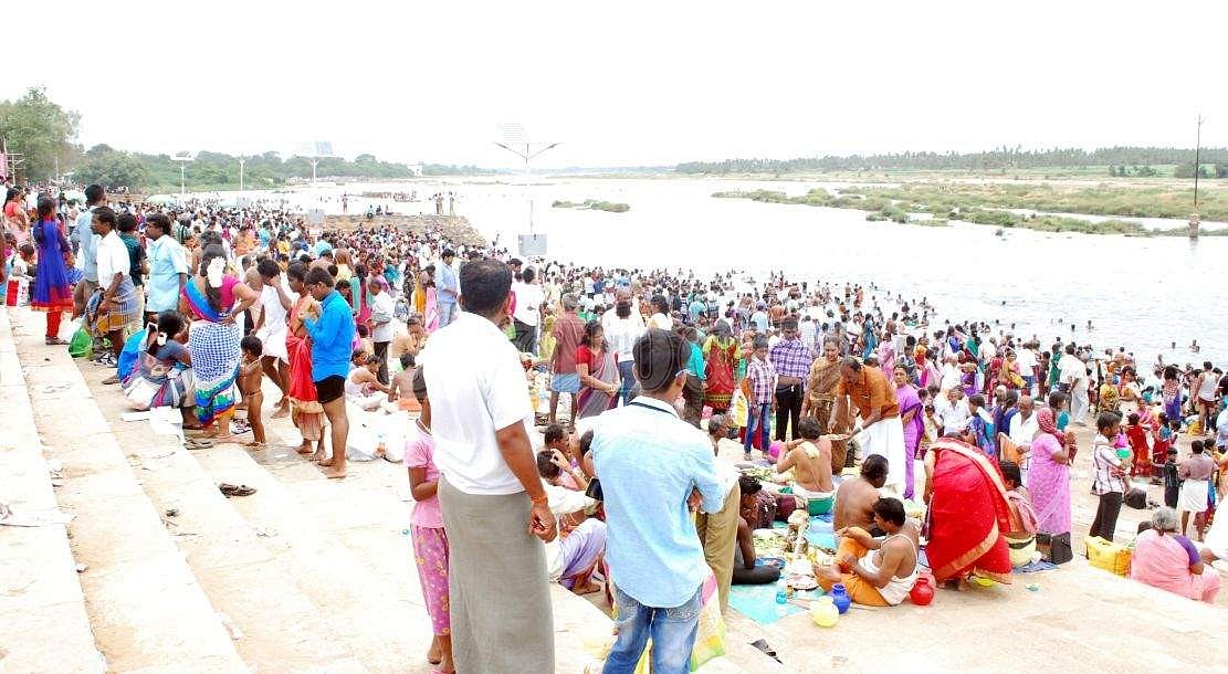 கோயில் அருகில் உள்ள காவிரி ஆற்றில் புனித நீராடும் பக்தர்கள்.