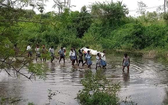 இடுப்பளவு நீரோடை தண்ணீரில் சடலத்தை எடுத்துச் சென்ற உறவினர்கள்.