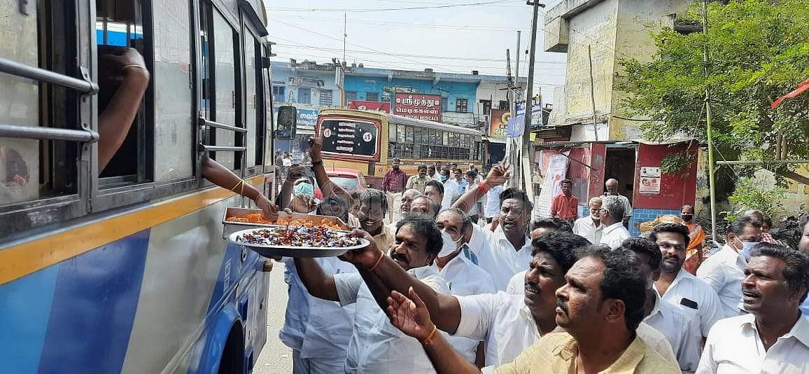 பேருந்து பயணிகளுக்கு இனிப்பு வழங்கும் அதிமுகவினர்.