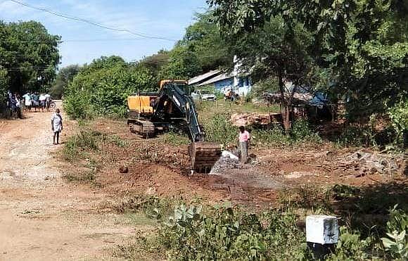 ராட்சத இயந்திரம் கொண்டு அடைப்பினை நீக்கும் பணியில் ஈடுபட்ட ஊழியர்கள்.